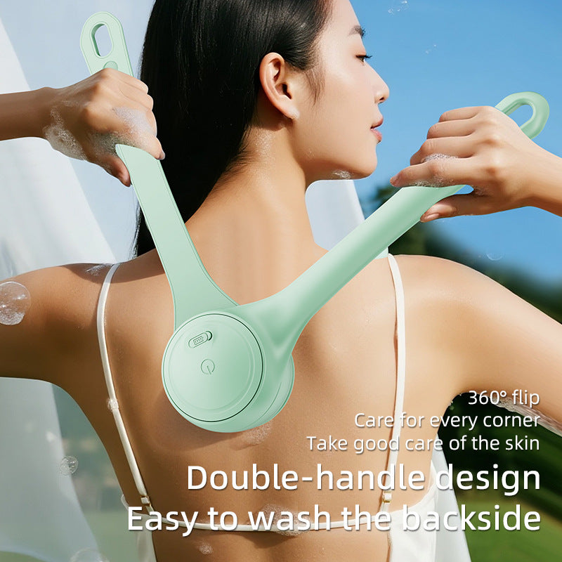 Person using a green shower head with double handles to wash their back outdoors.